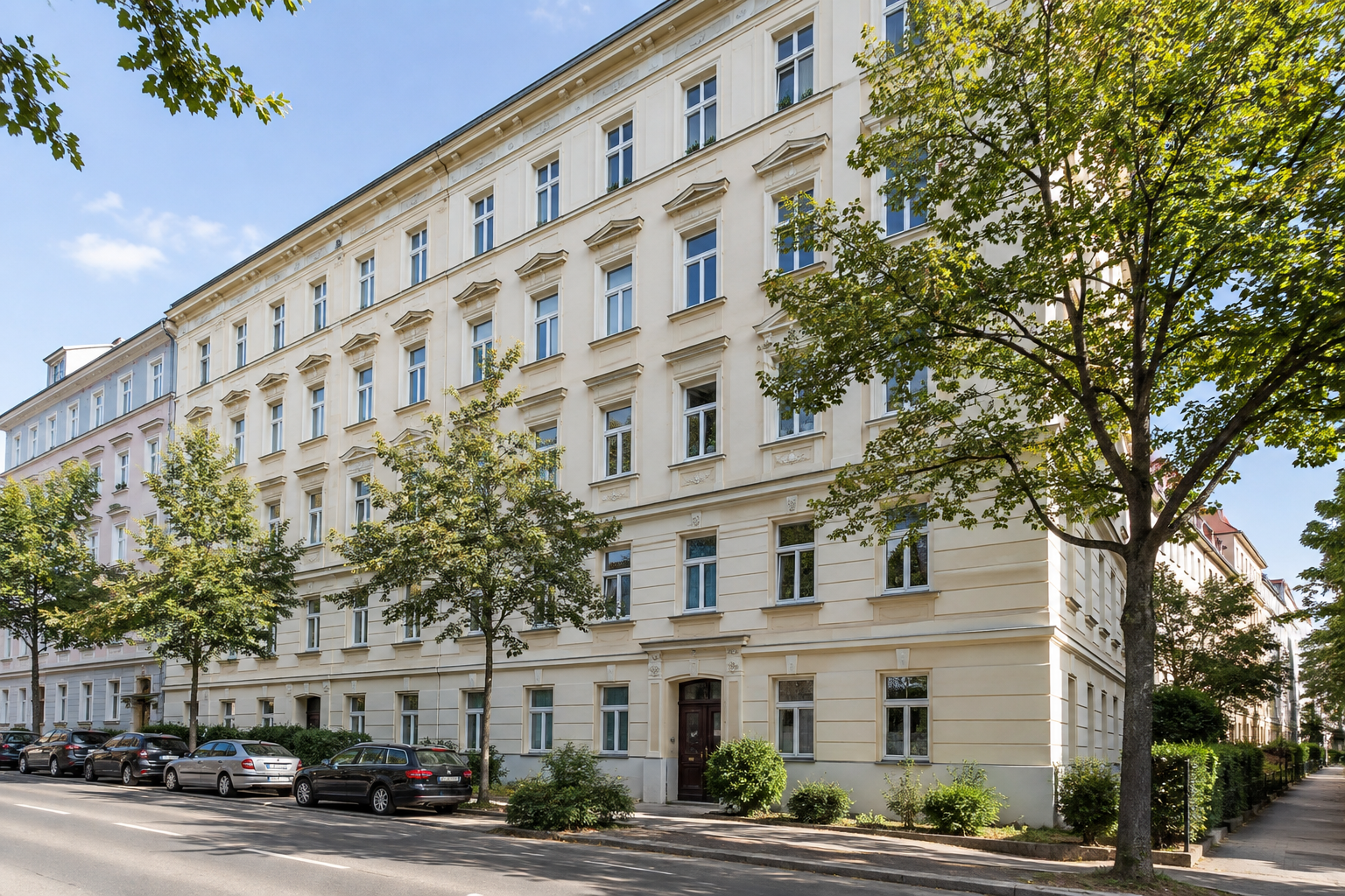 Mehrgeschossiges Zinshaus an einer baumbestandenen Straße